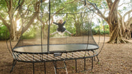 Load image into Gallery viewer, young girl jumping high on an outdoor trampoline
