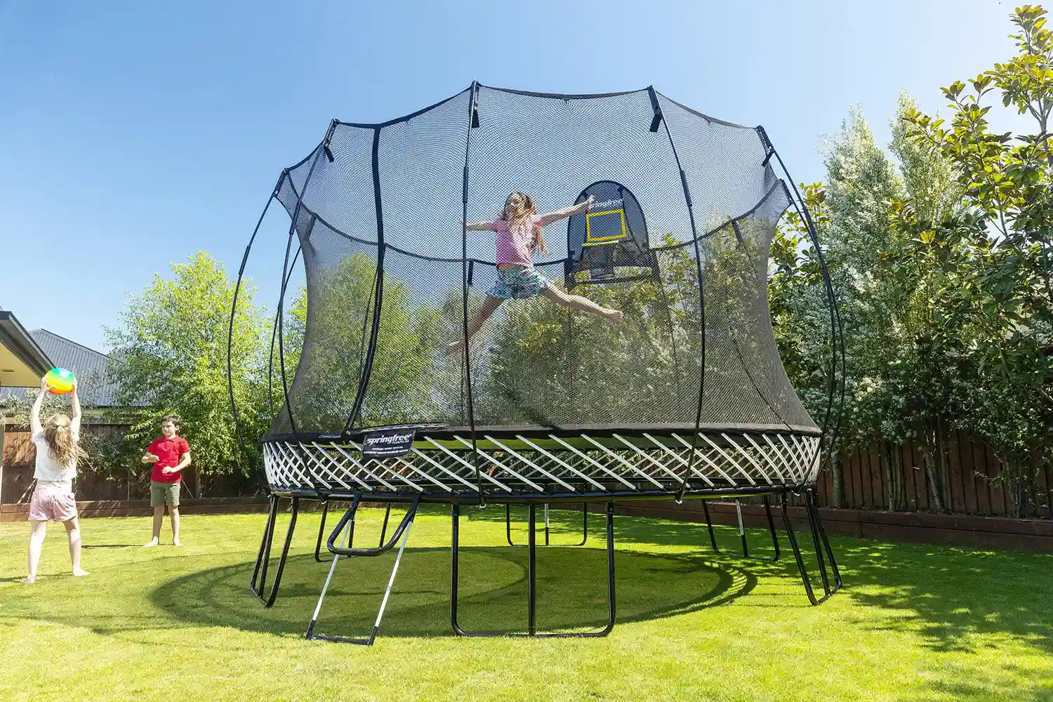 a girl jumping high on an outdoor trampoline