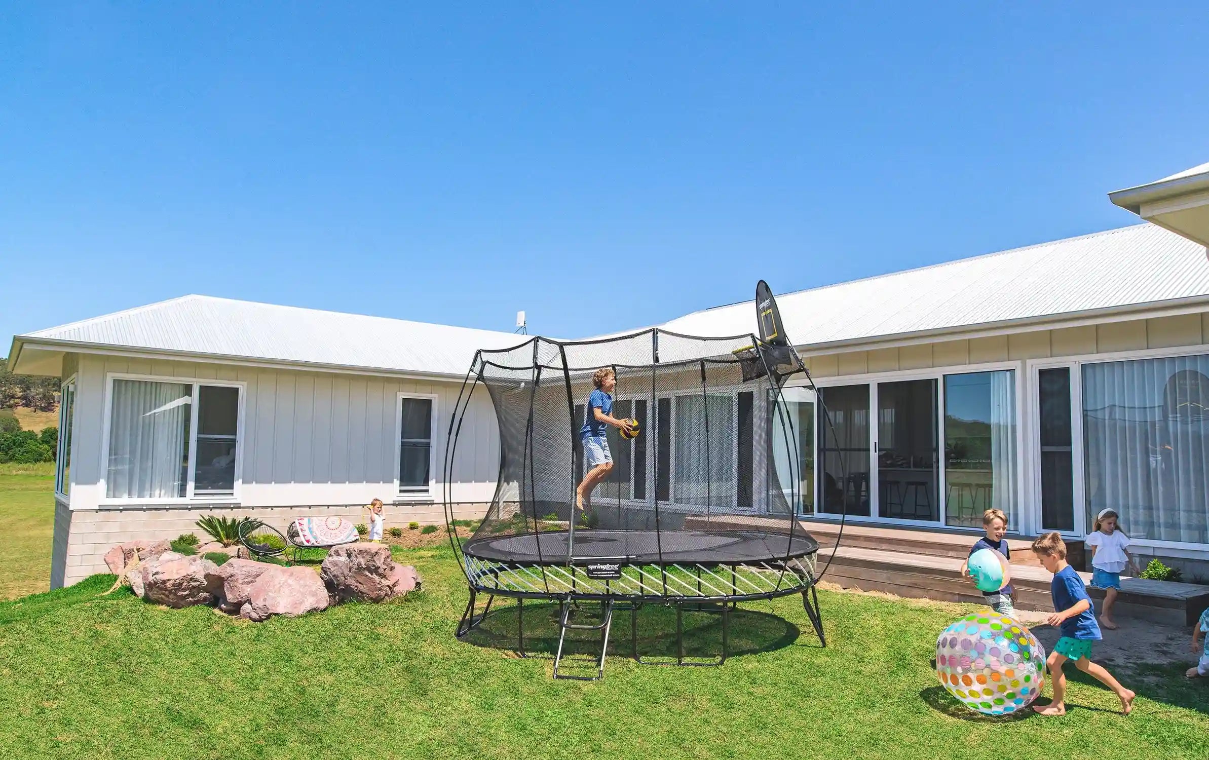 Boy playing basketball on an outdoor trampoline